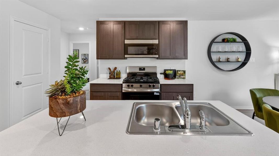 Kitchen island with an undermount double basin stainless steel sink, stainless steel faucet, and white countertop Kitchen island with an undermount double basin stainless steel sink, stainless steel faucet, and white countertop