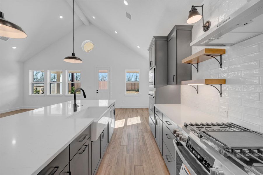 Gorgeous kitchen with grey cabinets, quartz counters, and stainless appliances