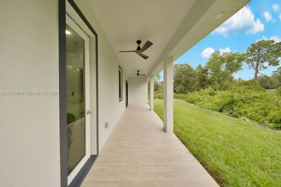 Covered patio featuring neutral-toned tile flooring, recessed ceiling lighting, and integrated ceiling fans