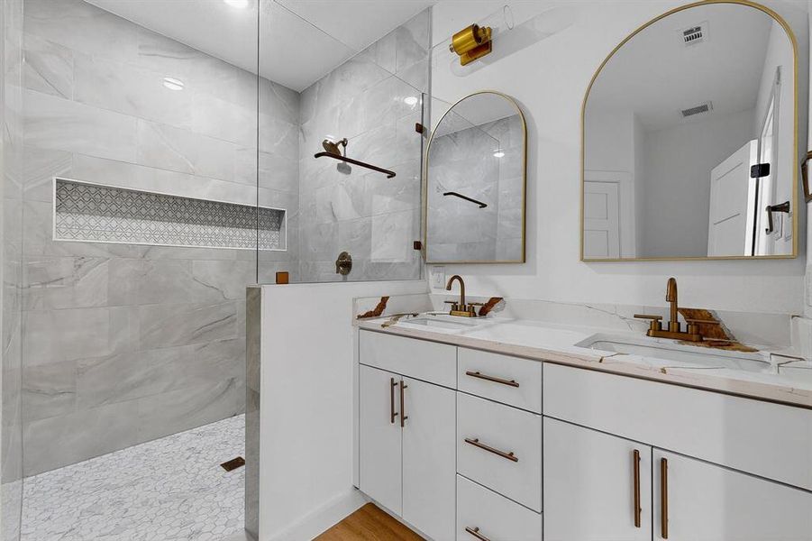 Bathroom featuring a walk in shower and double vanity Bathroom featuring a walk in shower and double vanity