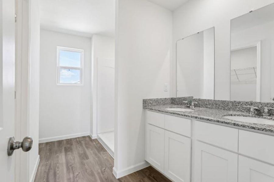 A bathroom with white cabinets.