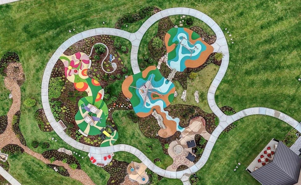 Aerial view of The 1824 and Austin Point’s beautifully designed community green space, featuring a children’s play area, gathering spaces, scenic walking paths, and an expansive event lawn.