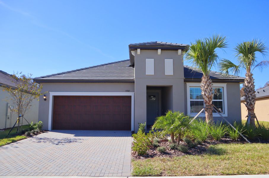 Front exterior of a new home in Angeline Active Adult: Active Adult Manors, Land O' Lakes, FL, highlighting curb appeal (Image 1).