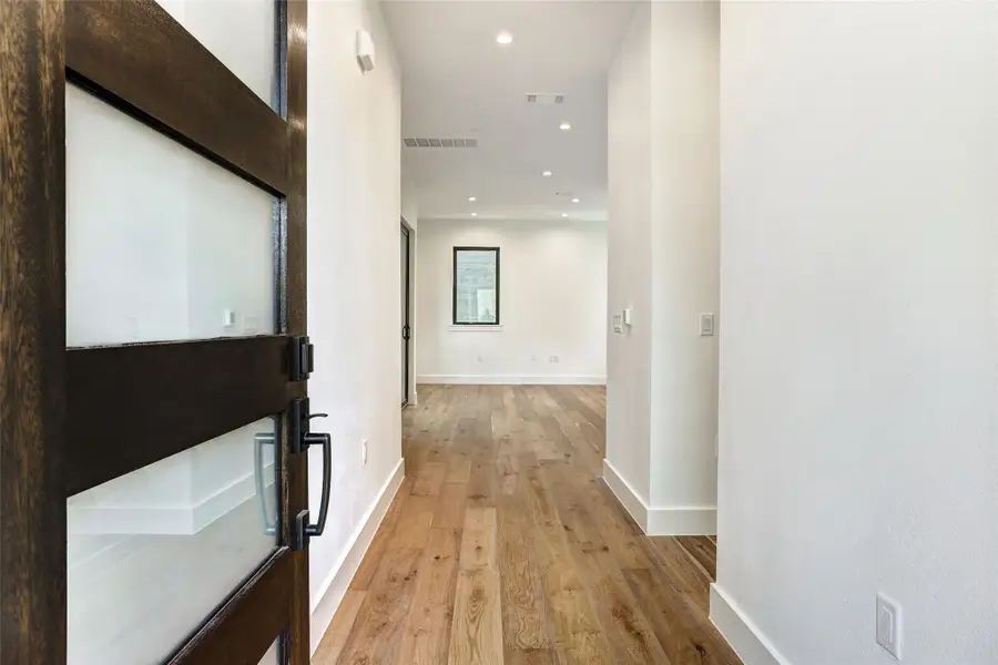 Hall featuring light wood-type flooring, baseboards, and recessed lighting