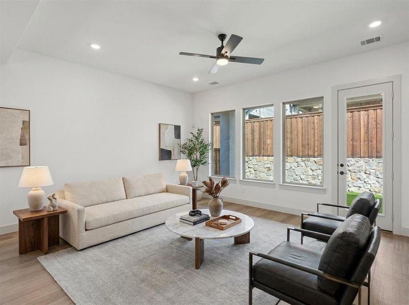 Bright living space featuring wood-finish flooring, recessed lighting, and a modern ceiling fan