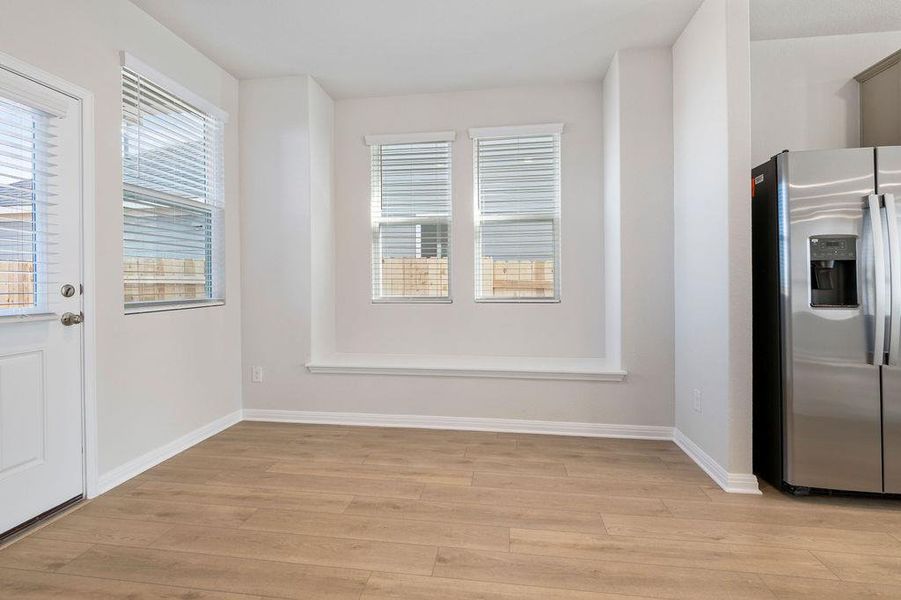Unfurnished dining area with light wood-type flooring and baseboards
