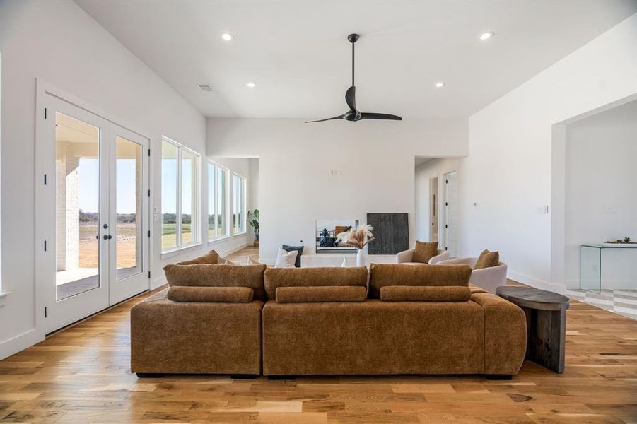 Living room with french doors, ceiling fan, and light wood-type flooring