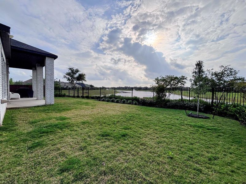 Spacious backyard with a well-maintained lawn and a covered patio area.