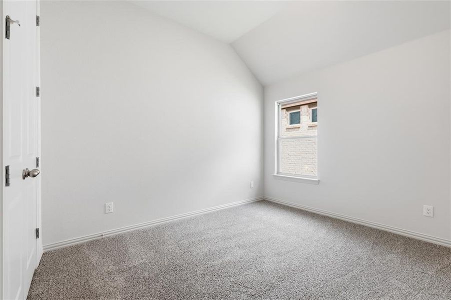 Spare room with carpet floors and lofted ceiling