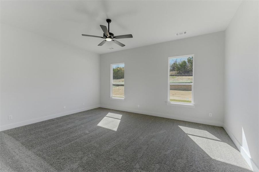 Empty room with carpet flooring and a ceiling fan