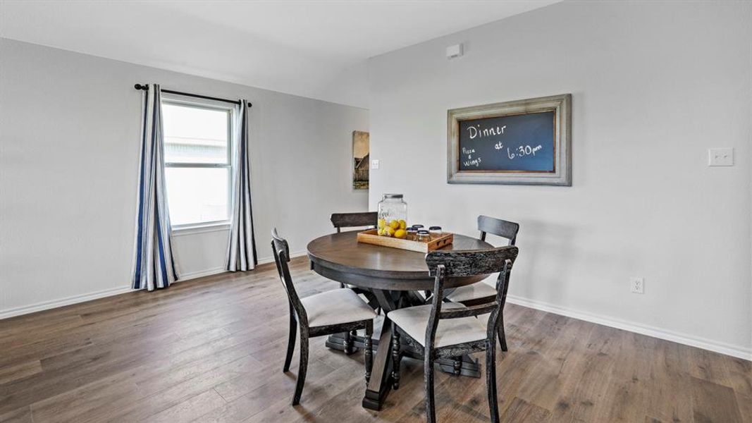Dining area featuring wood-finish flooring, a double-hung window, and neutral wall tones