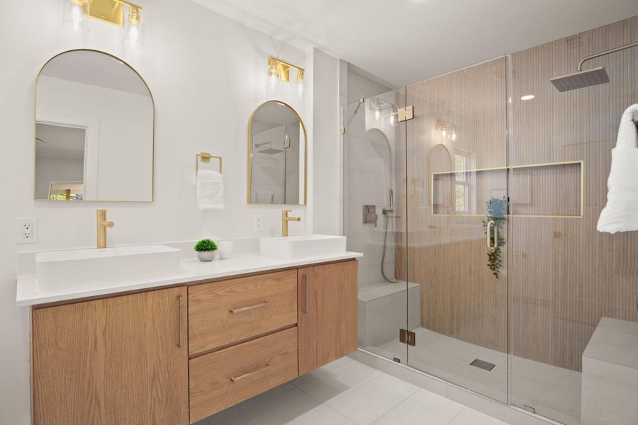 Full bathroom with double vanity, a stall shower, and light tile patterned floors