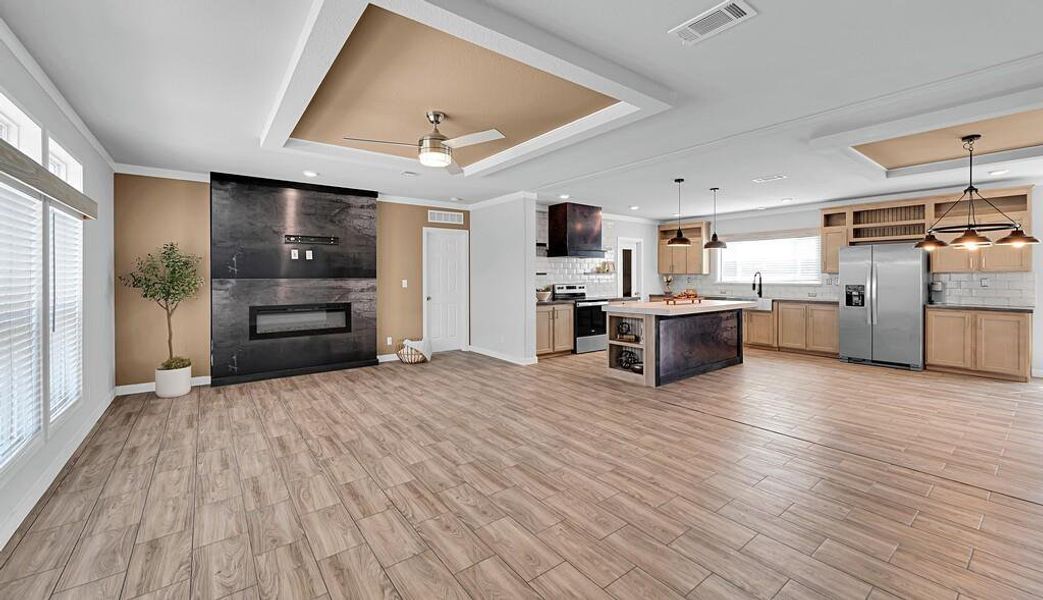 Kitchen with a tray ceiling, open shelves, open floor plan, stainless steel appliances, and ornamental molding Kitchen with a tray ceiling, open shelves, open floor plan, stainless steel appliances, and ornamental molding