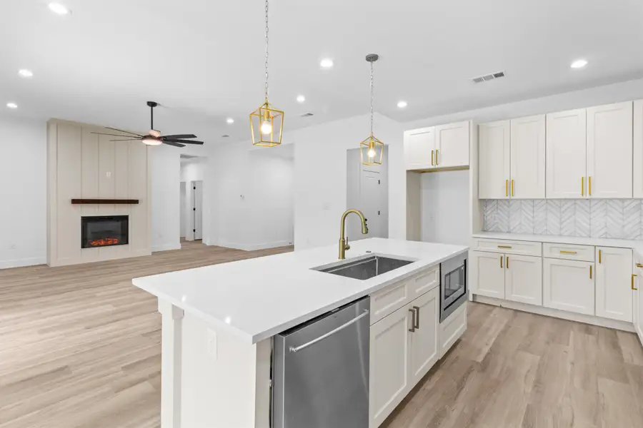 Kitchen featuring tasteful backsplash, stainless steel appliances, decorative light fixtures, light wood finished floors, and recessed lighting