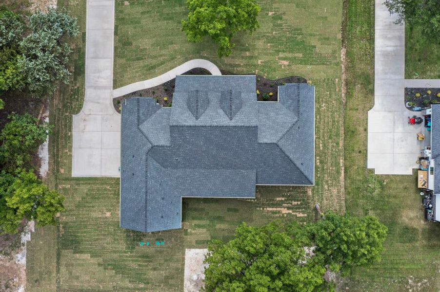 Expansive property featuring a multi-gabled roofline, concrete driveway, and a curved paved walkway