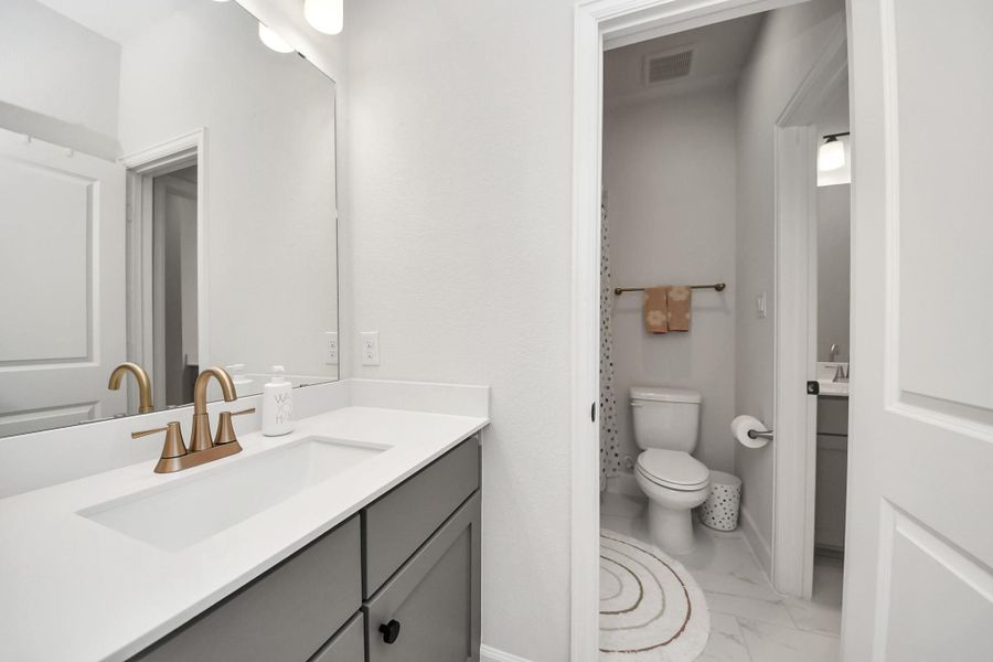 Clean vanity space with direct access to full bathroom.