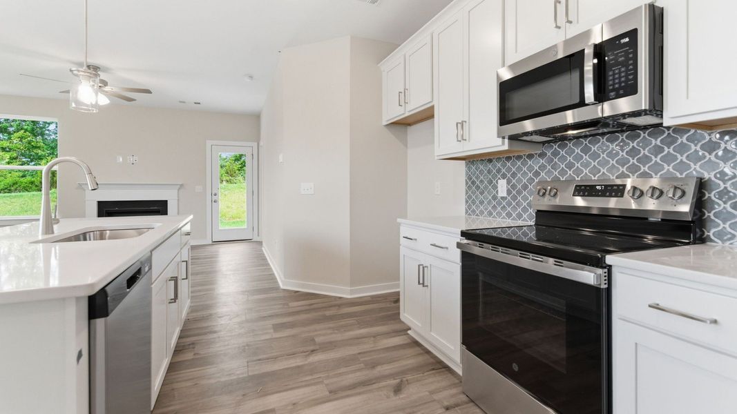 Kitchen with tile backsplash, pendant lighting, and quartz countertops Kitchen with tile backsplash, pendant lighting, and quartz countertops