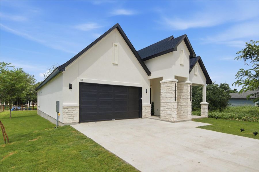 A striking modern facade with contrasting dark rooflines and light-colored stone accents invites you inside. A striking modern facade with contrasting dark rooflines and light-colored stone accents invites you inside.