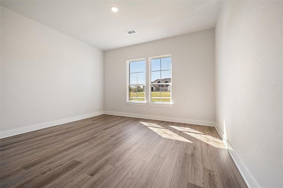 Empty room featuring wood finished floors and recessed lighting Empty room featuring wood finished floors and recessed lighting