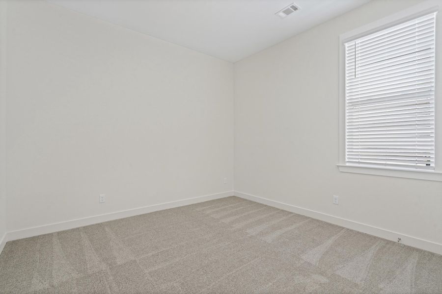 Neutral-toned walls complement the light gray carpet flooring