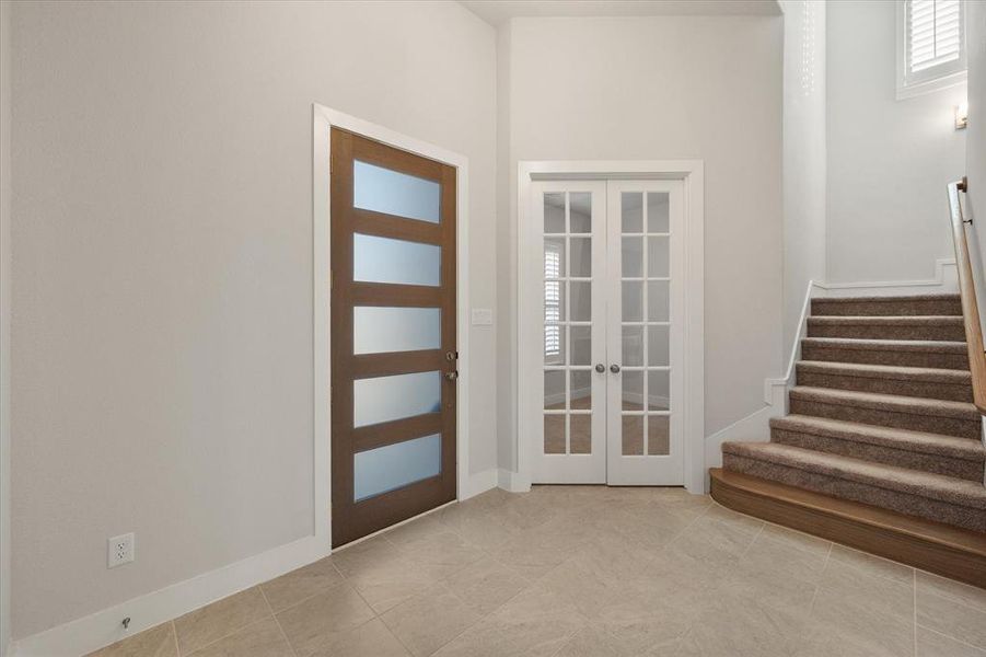 Entrance foyer with 8 foot door, tile flooring and french doors lead to dedicated office.