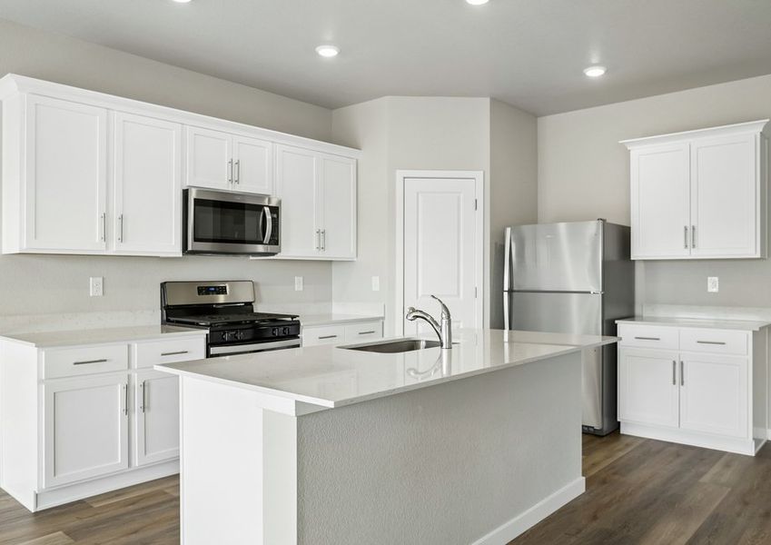 The kitchen has stainless steel appliances and plank flooring.