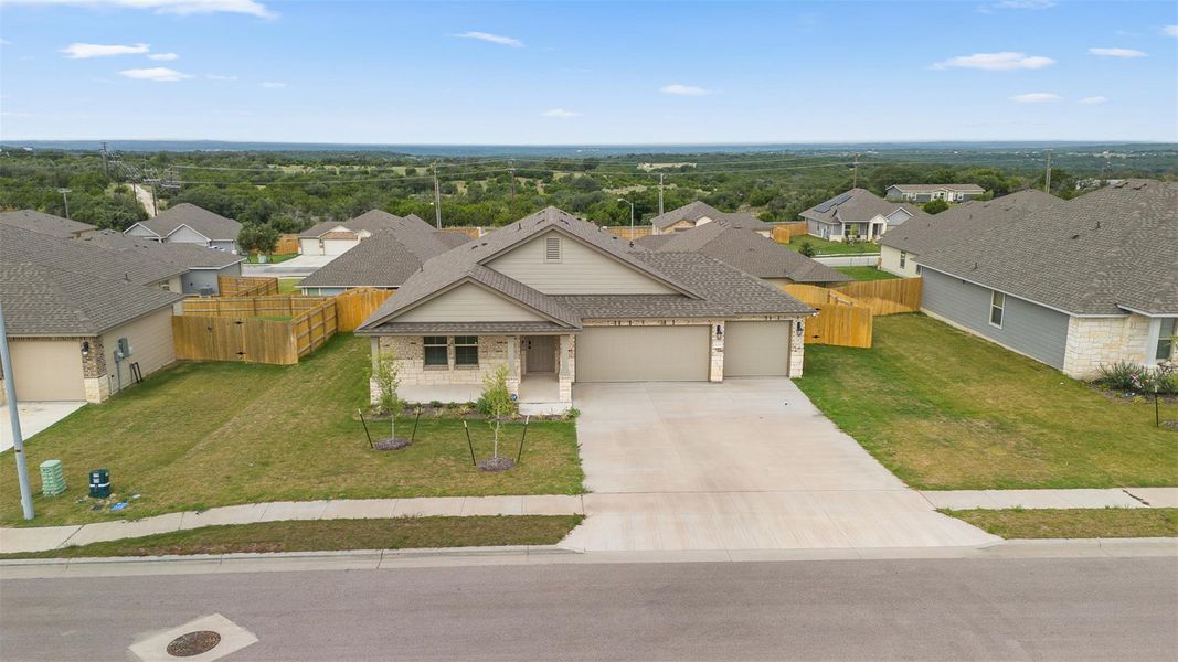 View of front of home with a residential view, an attached garage, concrete driveway, and a shingled roof