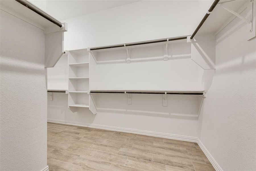 Spacious closet with light wood-style floors Spacious closet with light wood-style floors