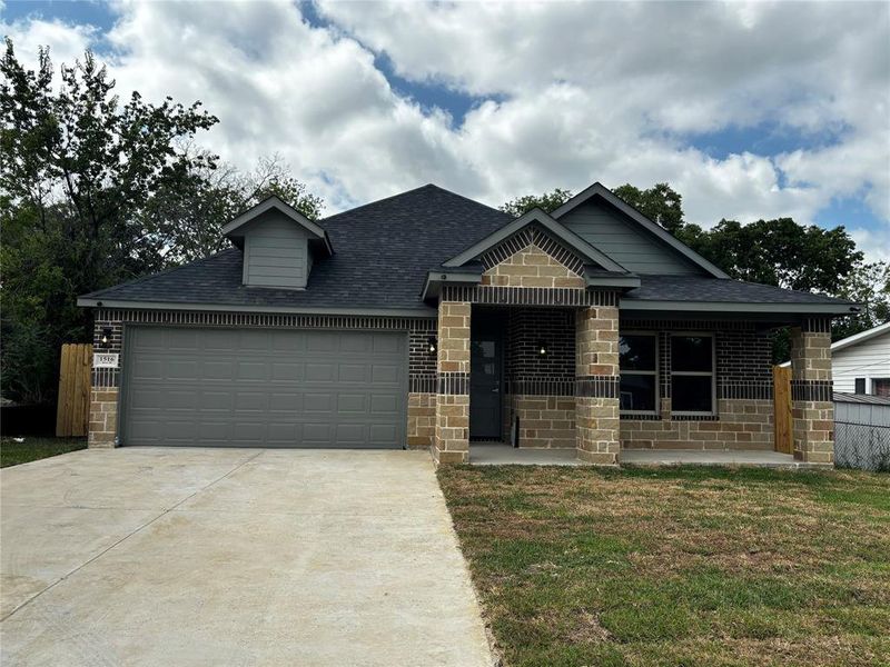 View of front of property with a garage and a front yard