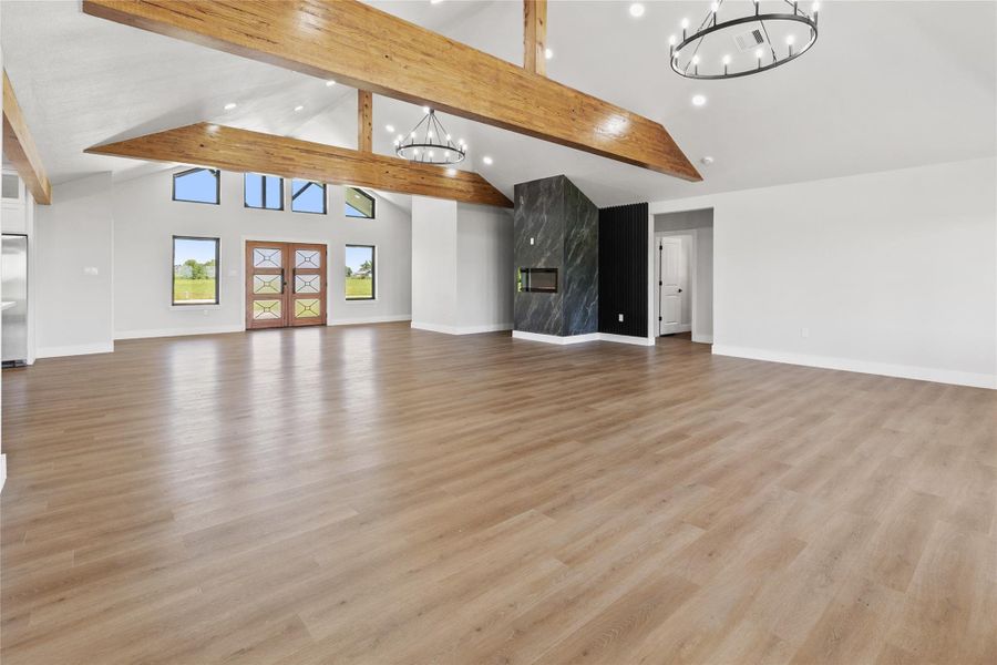 The open-concept living, dining, and kitchen areas are designed to take advantage of the home's unobstructed views. Vaulted ceilings, exposed beams, and modern lighting create a bright and inviting atmosphere.