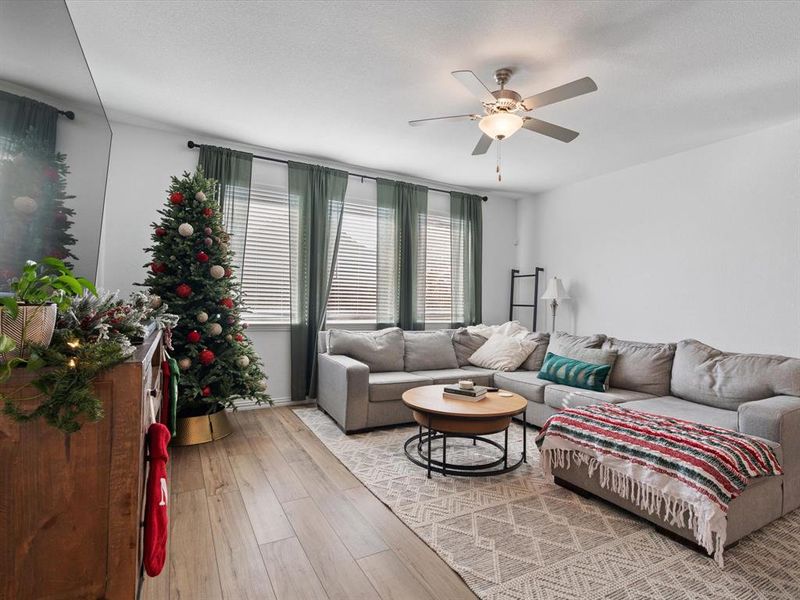 Living room with light wood-type flooring and ceiling fan