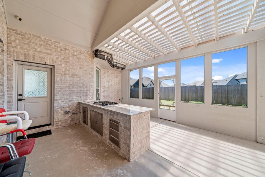 Extended covered patio with built-in outdoor kitchen, perfect for entertaining and enjoying year-round outdoor living.