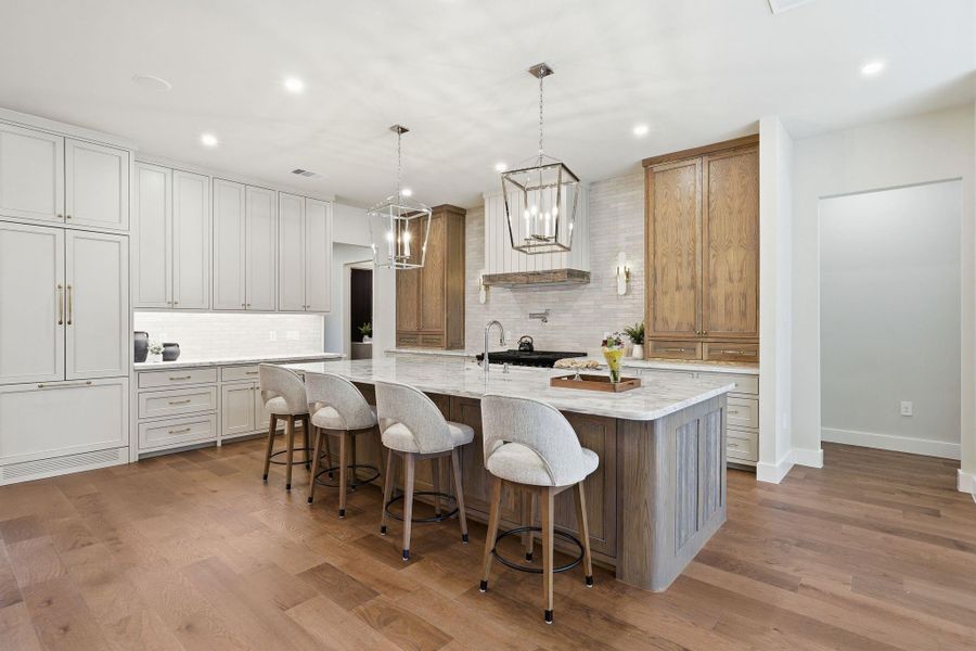 Jaw-dropping chef’s kitchenanchored by marble countertops,rich custom cabinetry, acommercial grade gas range,and a massive island that stealsthe show