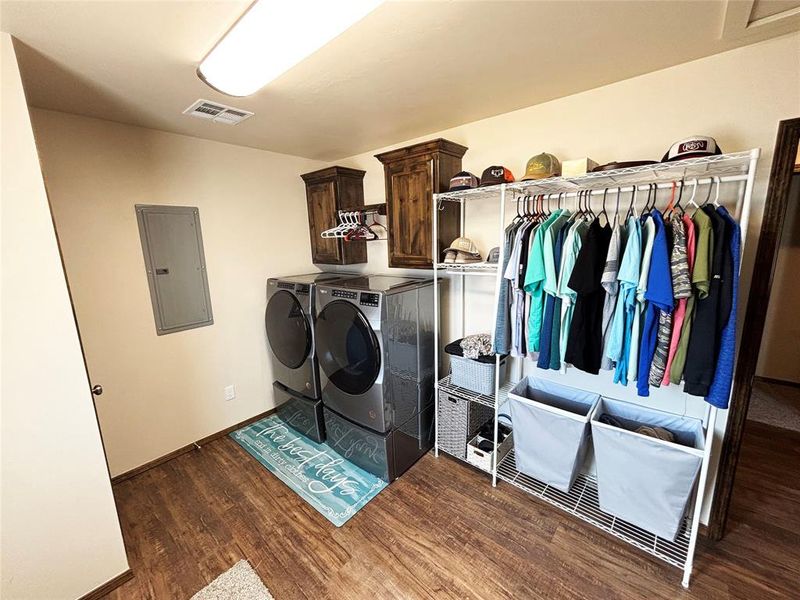 Washroom with electric panel, washing machine and dryer, and cabinet space Washroom with electric panel, washing machine and dryer, and cabinet space