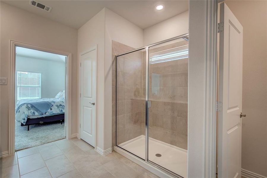 Bathroom with tile patterned floors and a shower with door