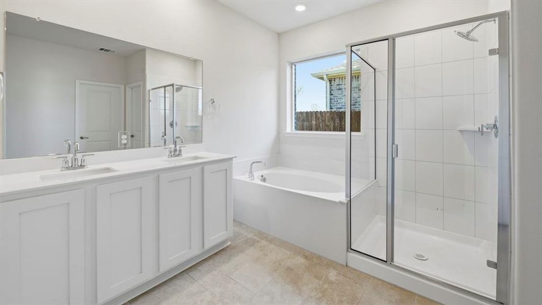 Bathroom featuring double vanity, a bath, a shower stall, and light tile patterned flooring Bathroom featuring double vanity, a bath, a shower stall, and light tile patterned flooring