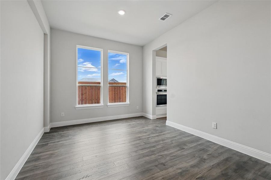 Empty room featuring dark wood finished floors, baseboards, and recessed lighting Empty room featuring dark wood finished floors, baseboards, and recessed lighting