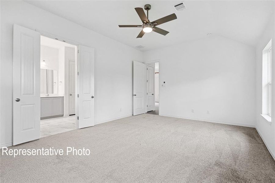 Carpeted room featuring a vaulted ceiling and a ceiling fan with integrated lighting
