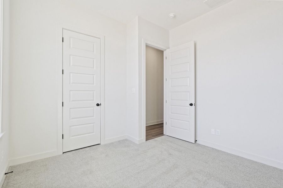 Unfurnished bedroom with light carpet and a closet