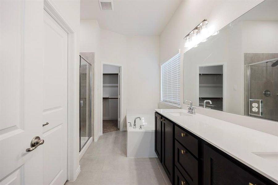 Bathroom featuring tile patterned floors, plus walk in shower, and vanity