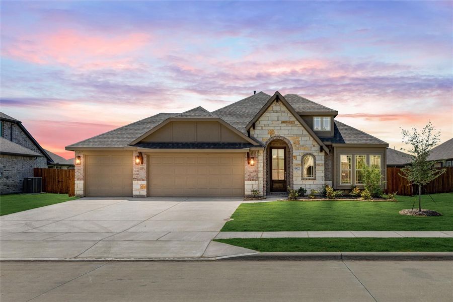 Single-story home with stone and brick exterior, three-car garage, arched entry, and green front lawn Single-story home with stone and brick exterior, three-car garage, arched entry, and green front lawn