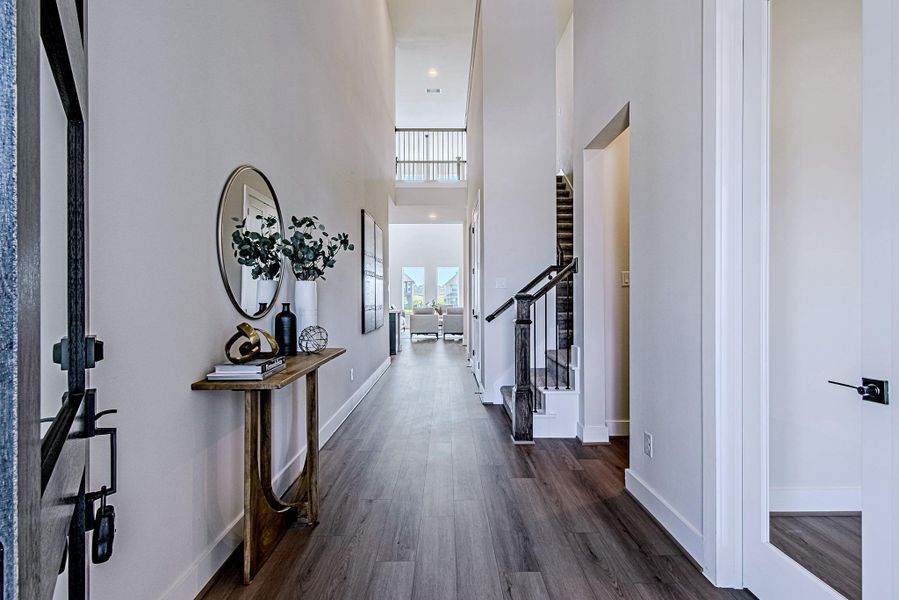 Bright entry hallway with wood-look flooring and a view toward the open living area