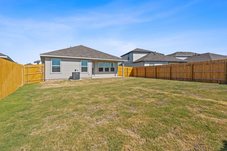 Back of property featuring roof with shingles and a fenced backyard
