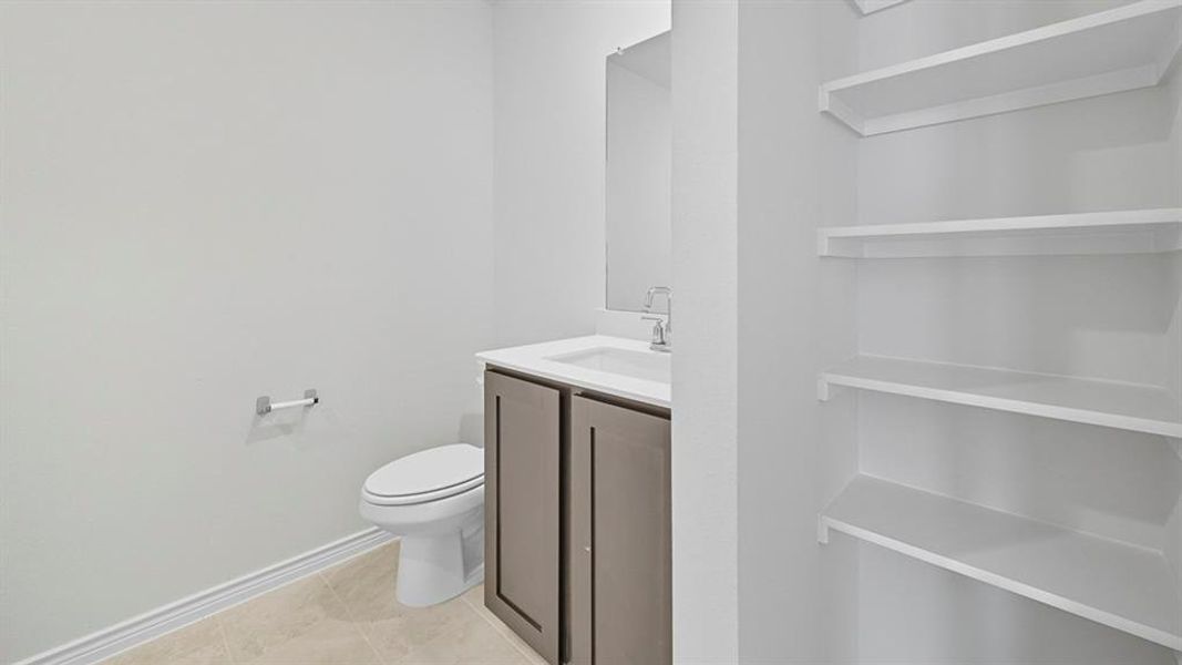Half bathroom featuring vanity and light tile patterned flooring
