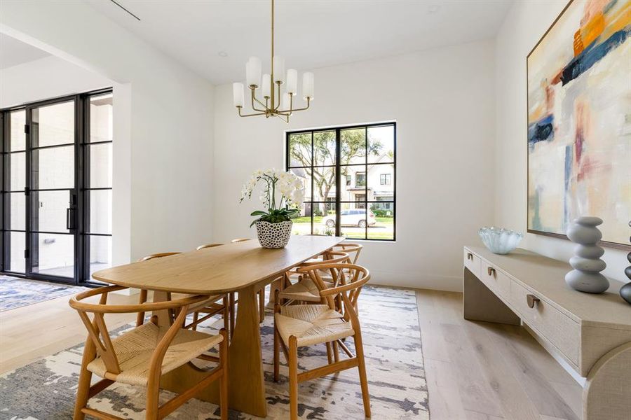 Dining space featuring light wood finished floors and a chandelier Dining space featuring light wood finished floors and a chandelier