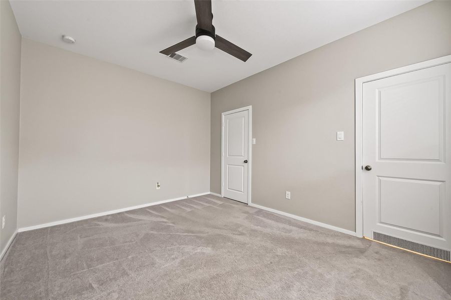 Spacious guest suite bedroom featuring neutral finishes, ceiling fan, and ample room for furnishings. Spacious guest suite bedroom featuring neutral finishes, ceiling fan, and ample room for furnishings.