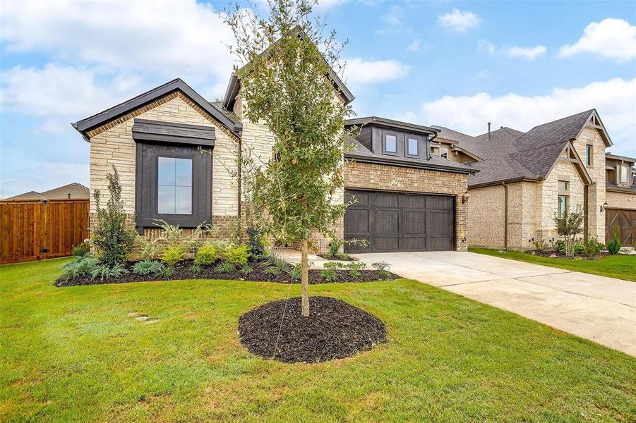 View of front of property with a garage and a front lawn