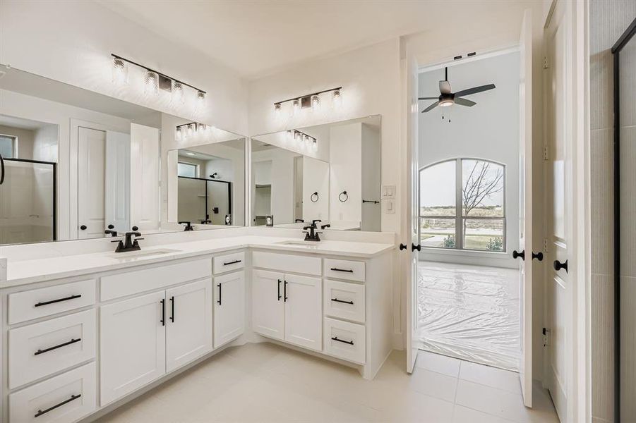 Full bath with a stall shower, double vanity, light tile patterned floors, and a ceiling fan Full bath with a stall shower, double vanity, light tile patterned floors, and a ceiling fan