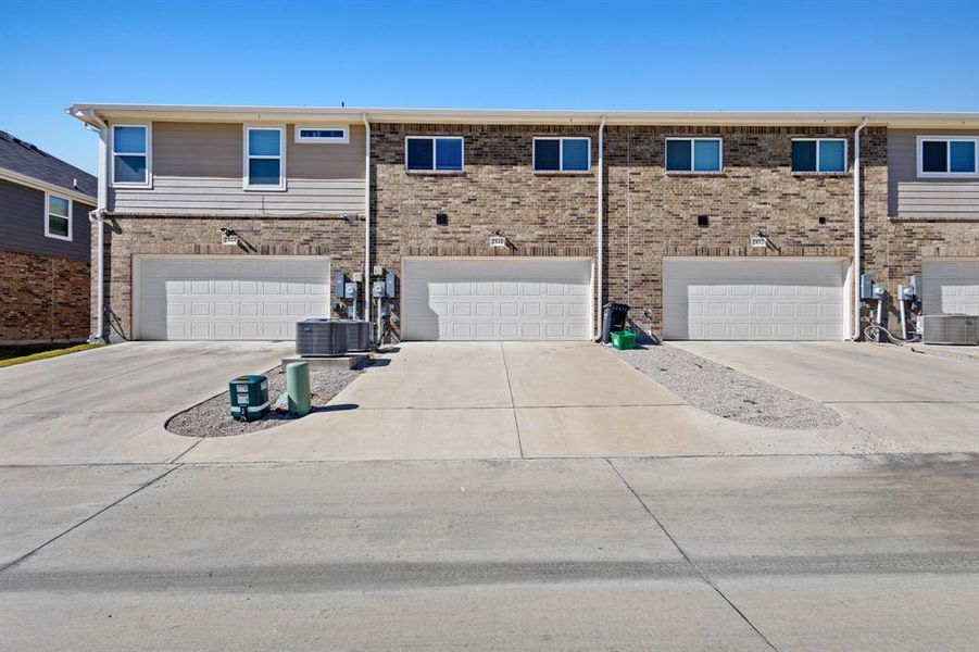 Rear view of property with driveway and a garage Rear view of property with driveway and a garage