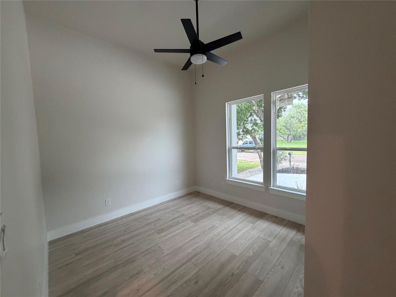 A quiet space with tall ceilings and modern flooring, perfect for a home office or cozy bedroom.